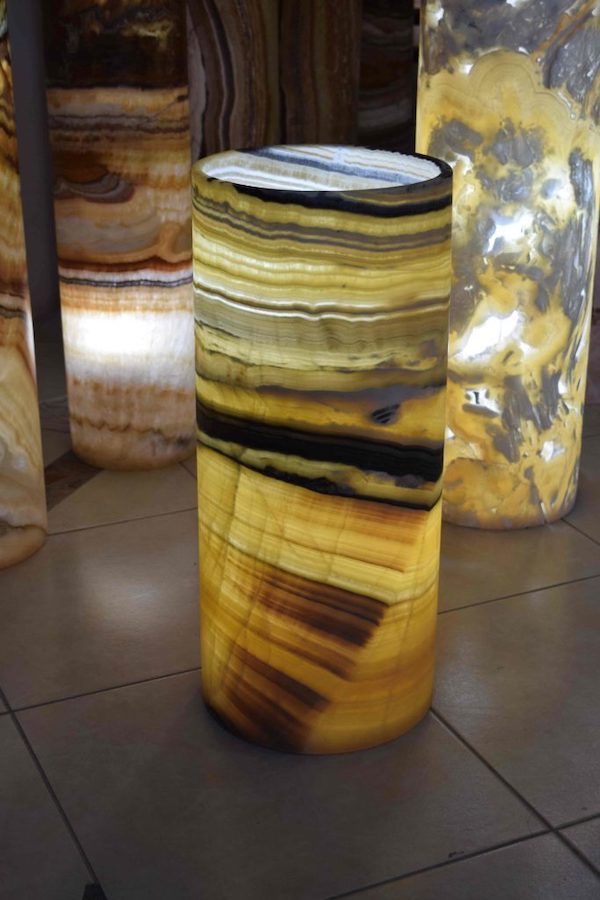 Marvellous cylindrical onyx floor lamp made from Galactea stone collection. Main colors: yellow, orange, black, and brown