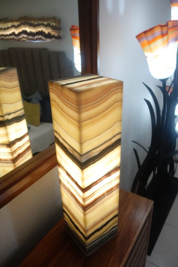 Onyx rectangular table lamp made from onyx Galactea marble standing next to the mirror