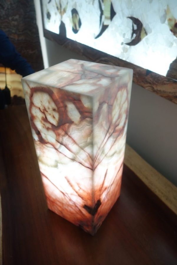 Small onyx table lamp of rectangular shape made from onyx Azulita stone. The lamp stands on the table next to the wall