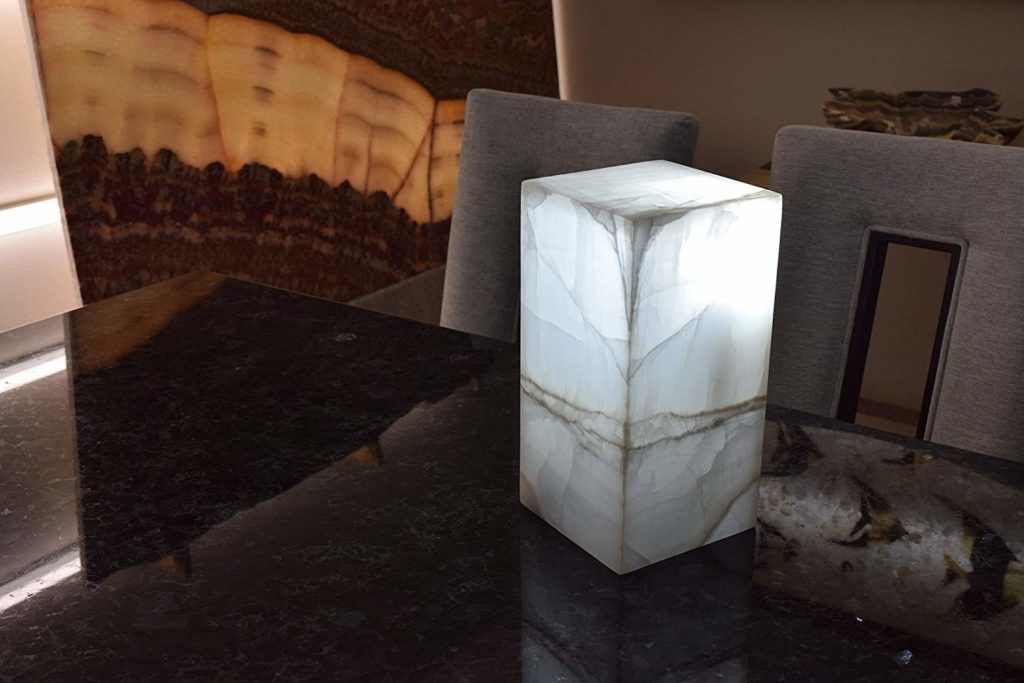 Small-sized rectangular onyx table lamp made of Blanco Hielo stone collection is featured on the dinner table with the light on.