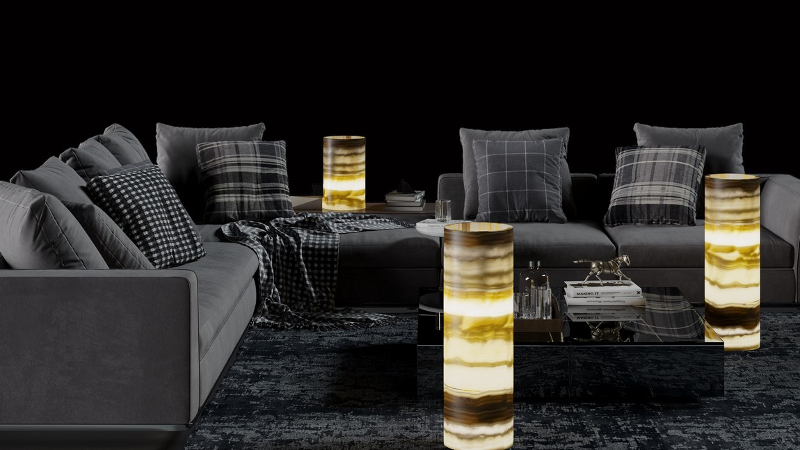 three cylindrical floor lamps made of onyx ambar stone fitted in the living room next to l-shaped sofa and small table