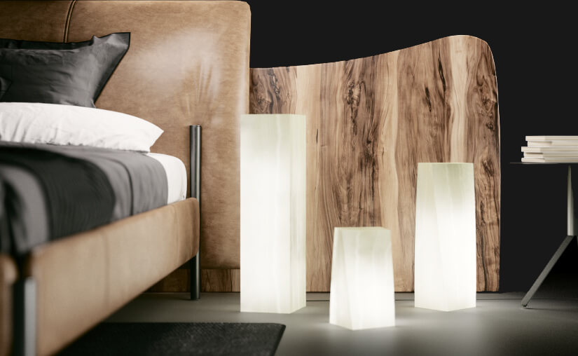 Three floor onyx lamps made from Blanco San Luis of different shapes and standing next to the bed.