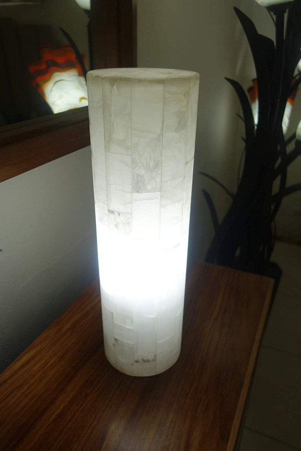 White onyx Blanco San Luis floor lamp standing next to the mirror with light on