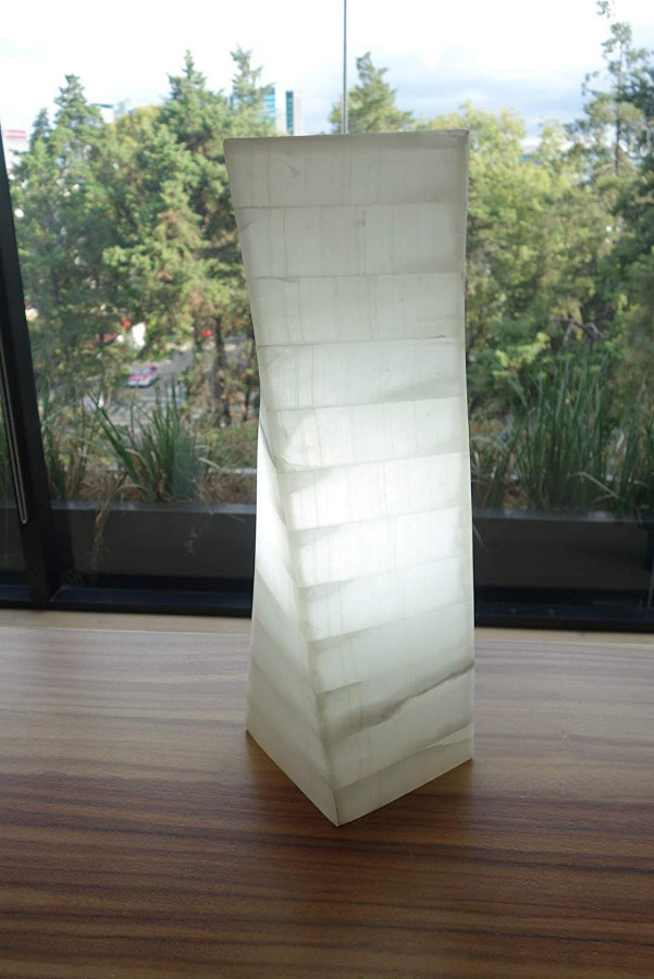 White twisted onyx floor lamp made from Blanco San Luis collection standing on the table with light on